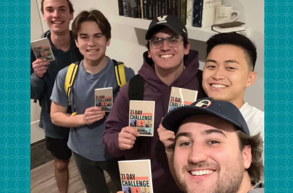 Five college-aged male students take a selfie with their 21 day reading challenge book in their hands.