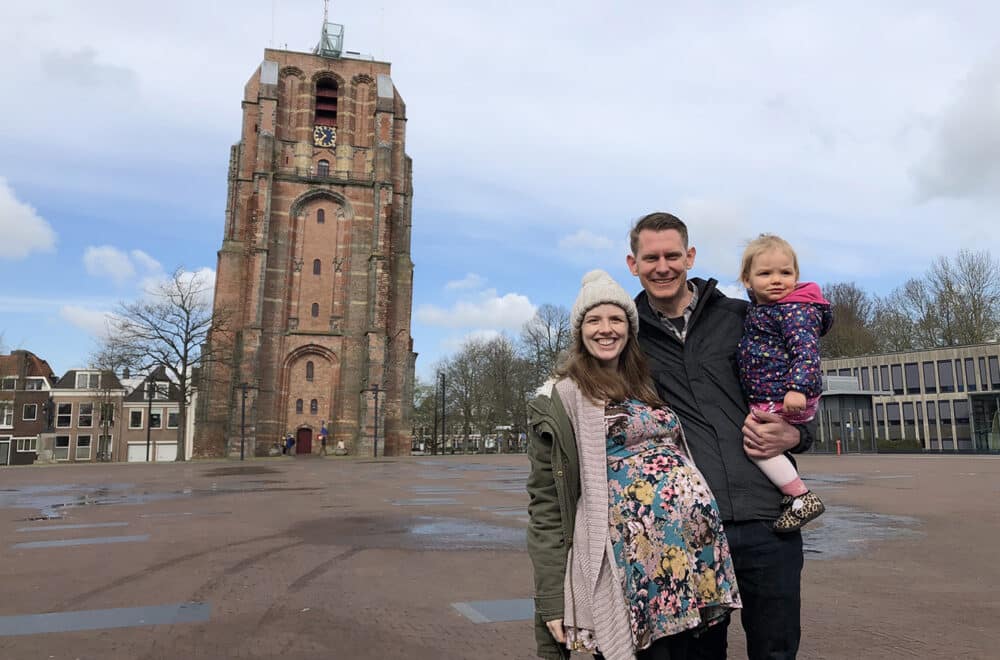 Joel and Libby stand with their daughter in front of the Oldehove tower in Leeuwarden